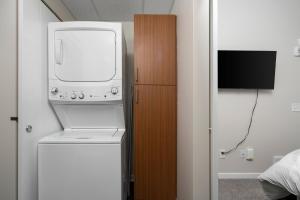 uma máquina de lavar e secar roupa num quarto com televisão em Sweet Tart Spot - Cozy TC Condo - Pet Friendly em Traverse City