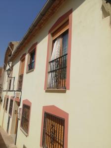ein weißes Gebäude mit schwarzen Fenstern in der Unterkunft Cruz de Vino in Caravaca de la Cruz
