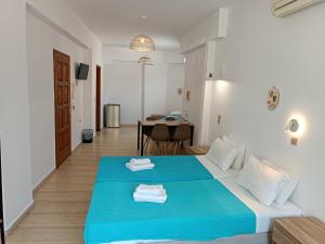 a bedroom with a blue bed and a table at Imeros in Chania