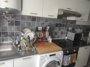 a kitchen with a sink and a washing machine at Begogane in Santurce