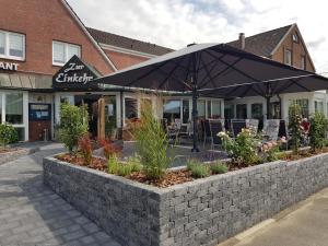 a patio with an umbrella in front of a restaurant at Kiek In Hotel Zur Einkehr in Stade