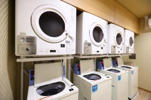 a row of washers and dryers in a room at Dormy Inn Express Fujisan Gotemba in Gotemba