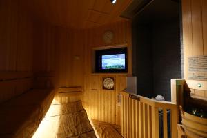 a room with a tv and a couch in a room at Dormy Inn Express Fujisan Gotemba in Gotemba