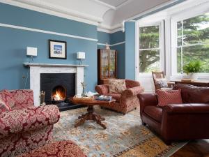 uma sala de estar com dois sofás e uma lareira em Broomhouse Farmhouse em Cheswick