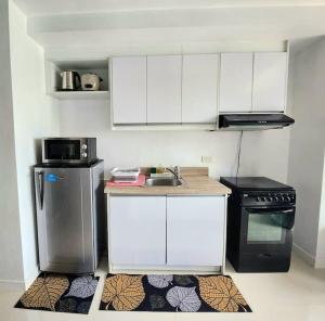 uma pequena cozinha com um lavatório e um fogão em Nice and Cozy Studio near Greenbelt Makati with Balcony em Manila