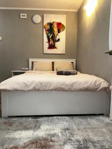 1 dormitorio con 1 cama con una pintura en la pared en One Room Apartment Decebal, en Bucarest