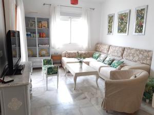 ein Wohnzimmer mit einem Sofa und einem Tisch in der Unterkunft El Capricho de Espartinas in Espartinas