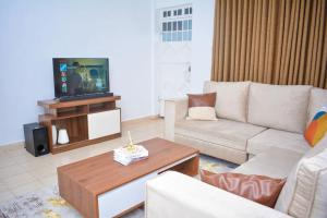 un soggiorno con divano e TV di Comfy, stylish, and family-friendly apartment in Karatina Town a Karatina