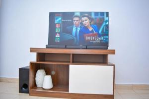 una TV a schermo piatto seduta sopra un tavolo di Comfy, stylish, and family-friendly apartment in Karatina Town a Karatina