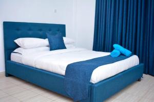 un letto blu con un orsacchiotto blu seduto sopra di Comfy, stylish, and family-friendly apartment in Karatina Town a Karatina