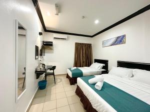 pokój hotelowy z dwoma łóżkami i biurkiem w obiekcie Hotel Tourist City Centre by HotSpot Essential w mieście Kota Kinabalu