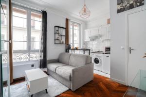 salon z kanapą i kuchnią w obiekcie Studio rénové cosy metro Paris 2pers wifi w Paryżu