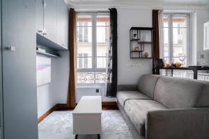 salon z kanapą i stołem w obiekcie Studio rénové cosy metro Paris 2pers wifi w Paryżu +12 zdjęć