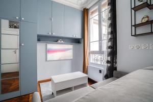 sypialnia z łóżkiem, stołem i oknem w obiekcie Studio rénové cosy metro Paris 2pers wifi w Paryżu