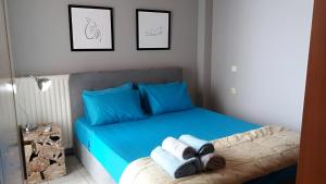 Un dormitorio con una cama azul con toallas. en 03 - Apt in the heart of the city - Heraklion, en Heraclión