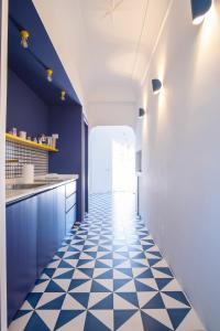 uma cozinha com armários azuis e piso em azulejo preto e branco em Il sorriso di Bri em Capri