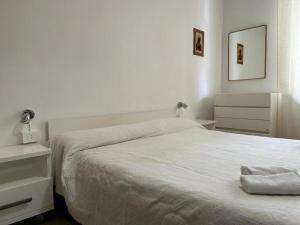 a white bedroom with a bed and a night stand at Best Way Rent - Casa Ida in Lavagna