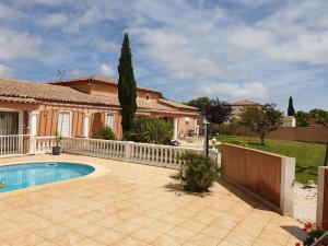 a house with a swimming pool and a fence at Villa plain pied avec piscine privée 8 personnes in La Crau