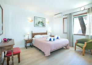a bedroom with a bed and a desk and a window at Owl Booking Villa Mariner - 5 Min Walk to the Beach in Pollença +22 photos