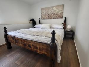 a bedroom with a wooden bed with a painting on the wall at Blue of the sea in Krapanj