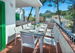 a table and chairs on the balcony of a house at Owl Booking Villa Mariner - 5 Min Walk to the Beach in Pollença