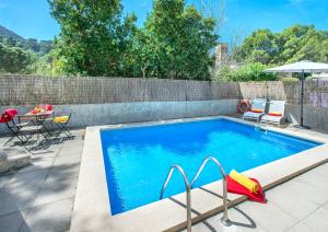 a swimming pool with two chairs and a table and a tablektop at Owl Booking Villa Mariner - 5 Min Walk to the Beach in Pollença
