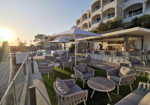 un patio al aire libre con sillas y mesas y un bar en Anthemis Hotel Apartments en Samos