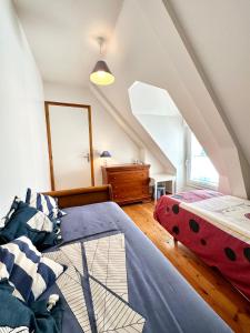 two beds in a bedroom with an attic at Maison de charme – Terrasse – 5min des plages in Port-Louis