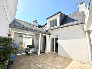 a white house with a patio in front of it at Maison de charme – Terrasse – 5min des plages in Port-Louis