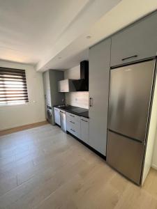 Il comprend une grande cuisine équipée d'un réfrigérateur en acier inoxydable. dans l'établissement Apartamento Luda, à Torreperogil