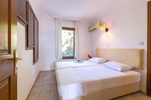 sypialnia z 2 łóżkami i oknem w obiekcie Korsan Apartment No.12 w Kaş