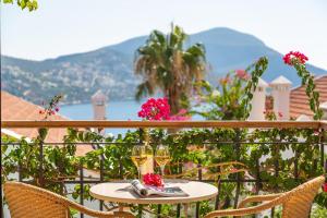 a table with two glasses of wine on a balcony at Korsan Apartment No.12 in Kaş