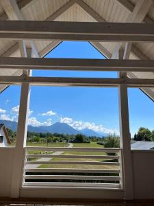 einen Blick auf die Berge durch ein Fenster in einem Gebäude in der Unterkunft Lodge Diana & Room Sweet 26 in Bled