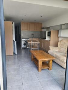 uma cozinha e sala de estar com uma mesa e um sofá em Appart 30 m2 cosy 2 personnes 1 grande chambre en mezzanine em Saint-Mitre-les-Remparts