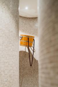 a bathroom with a wooden towel rack on a tiled wall at DCS Polana Jakuszycka in Szklarska Poręba