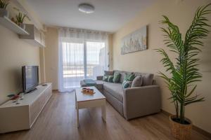 sala de estar con sofá y TV en Aqua - Apartamento a 250m playa, en La Pineda