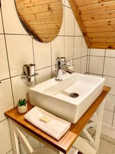 a bathroom with a white sink and a mirror at BorászPorta in Villány