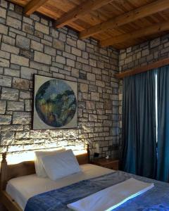 a bedroom with a brick wall and a bed in a room at Palermiti Luxury Rooms in Himare