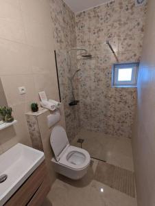 La salle de bains est pourvue d'une douche, de toilettes et d'un lavabo. dans l'établissement Two bedrooms apartment 50m from the beach, à Srima