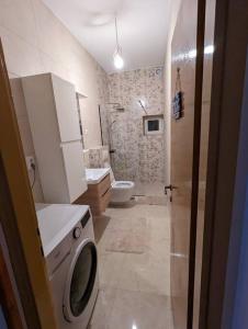 y baño con aseo y lavadora. en Two bedrooms apartment 50m from the beach, en Srima