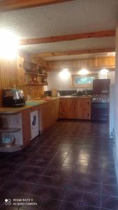 eine große Küche mit Holzschränken und Fliesenboden in der Unterkunft Садиба Живиця in Kozlin