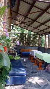 a patio with a table and benches and flowers at Садиба Живиця in Kozlin