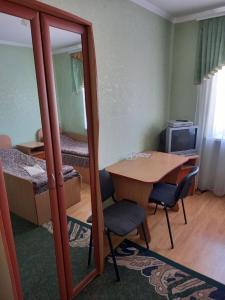 a small room with a table and a bedroom with a bed at Готель Поділля in Shestakovka
