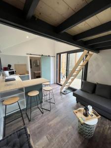 uma sala de estar com um sofá, uma mesa e cadeiras em Tiny House L’œil des Dômes em Saint-Pierre-le-Chastel
