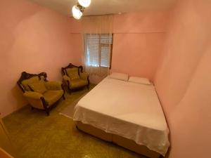 een slaapkamer met een bed en 2 stoelen bij Huzur için Şarköy'deki eviniz. in Şarköy