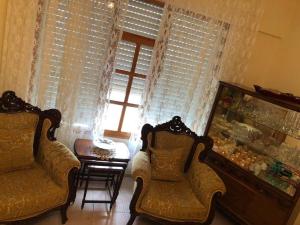 a living room with two chairs and a table and a window at Huzur için Şarköy'deki eviniz. in Şarköy