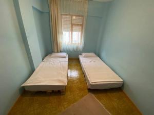 two beds in a small room with a window at Huzur için Şarköy'deki eviniz. in Şarköy
