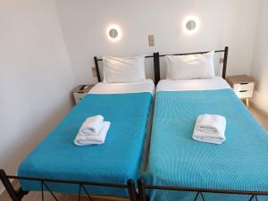 2 camas con toallas en una habitación en Imeros en La Canea
