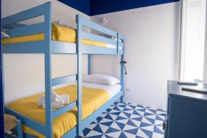 a bedroom with bunk beds with yellow and blue at Il Sorriso di Bri in Capri
