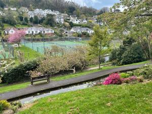a park with a bench and a tennis court at The Devonshire Villa in Ilfracombe